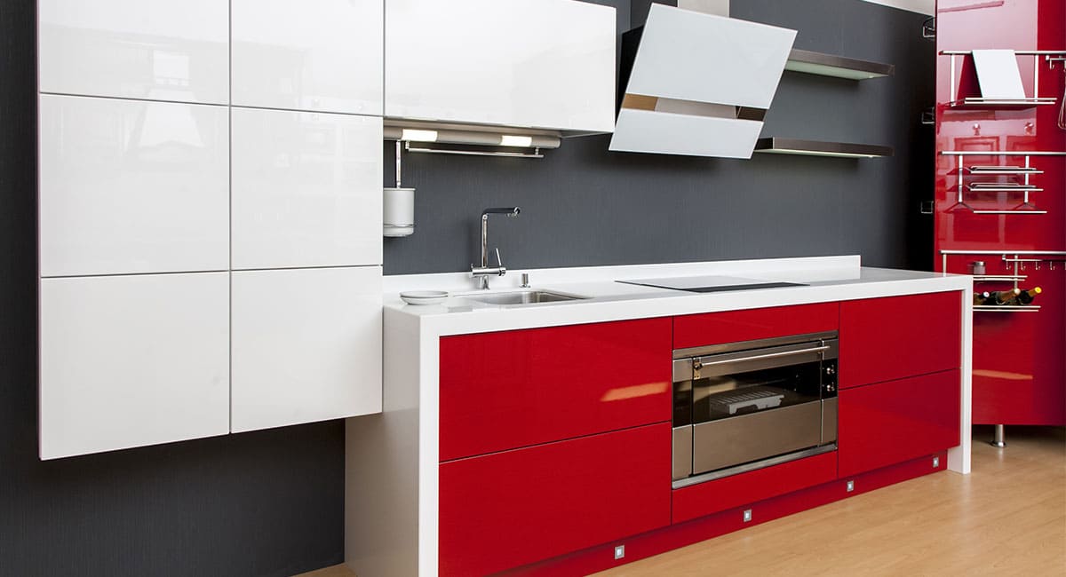 Modèle de cuisine design réalisée sur mesure avec placards rouges laqués et plan de travail blanc
