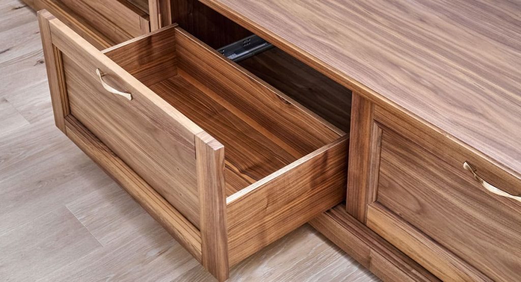 Meuble bas en bois massif avec tiroir ouvert, réalisé sur mesure par un artisan menuisier