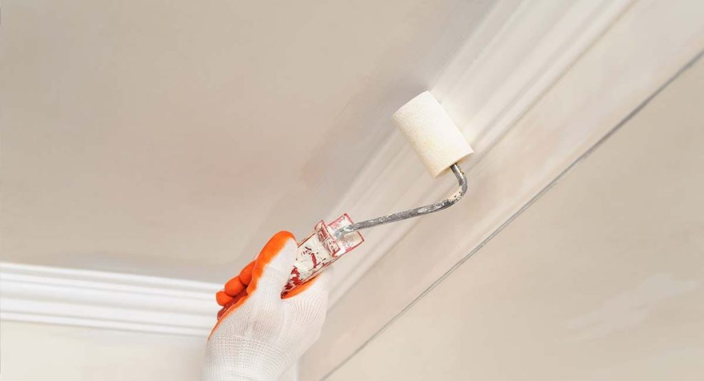 Peintre en bâtiment réalisant des finitions au plafond
