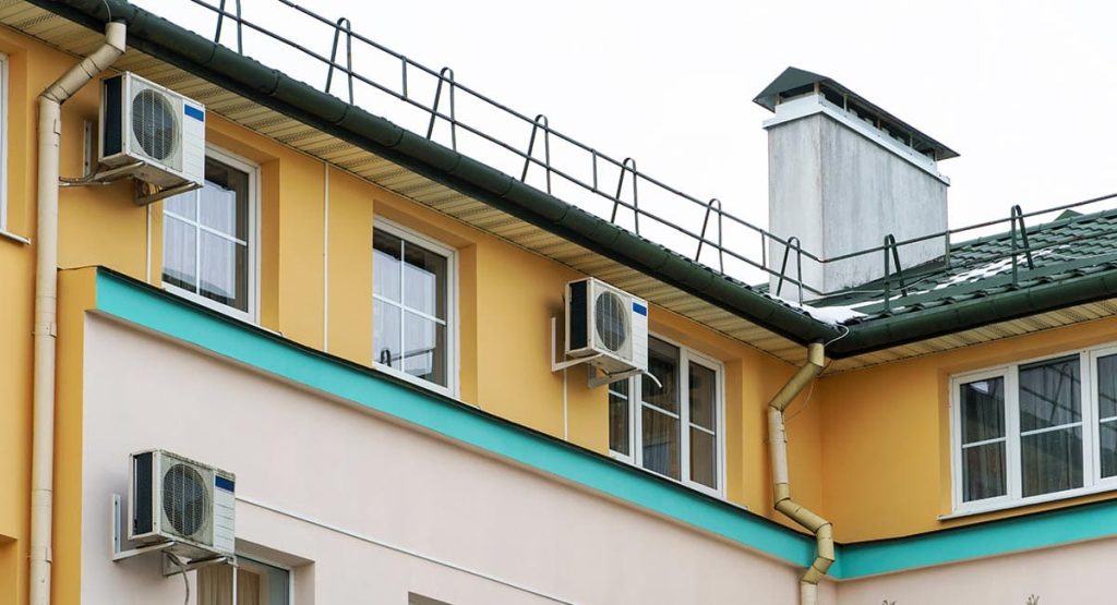Unités extérieures de climatisation installées sur la façade d’un immeuble en copropriété